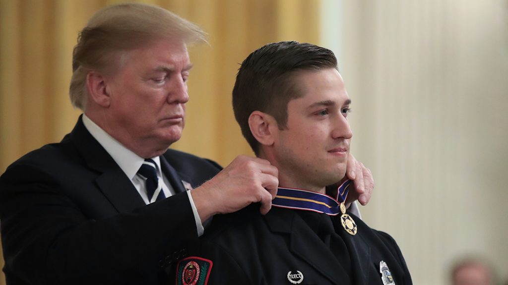 President Donald Trump awards Officer Alan Horujko of the Ohio State University Police, the Public Safety Officer Medal of Valor during a ceremony in the East Room of the White House in Washington, Wednesday, May 22.